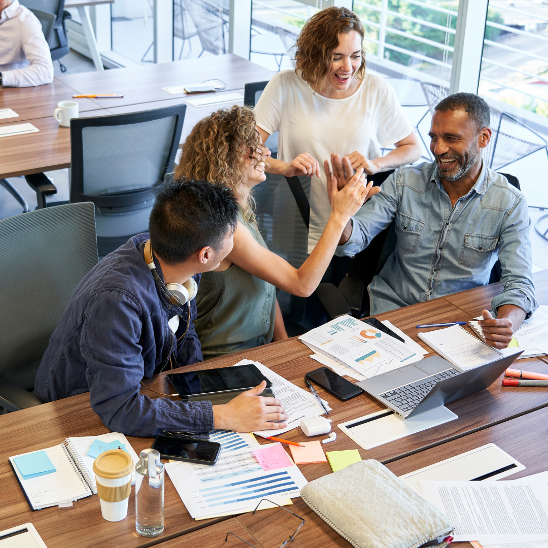 A group of people sitting around a desk